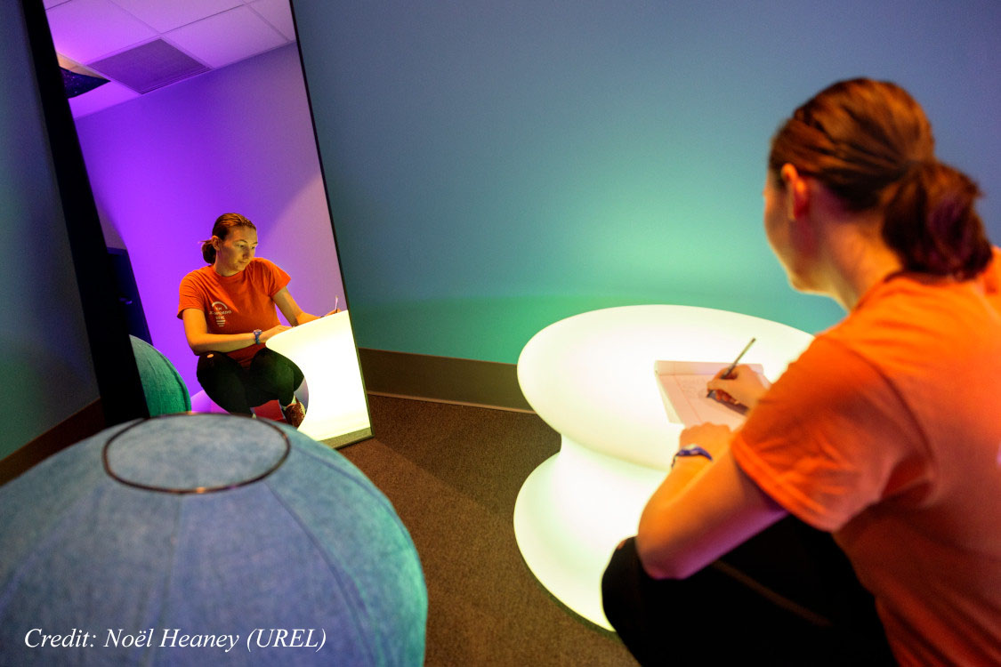 Becca McCabe, a neurodivergent doctoral student in mechanical engineering and president of the Student Neurodiversity Alliance at Cornell, looks through a nature book in the Learning Strategies Center's new sensory room.